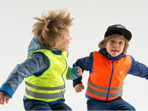 2 kindjes die springen met een fluohesje aan