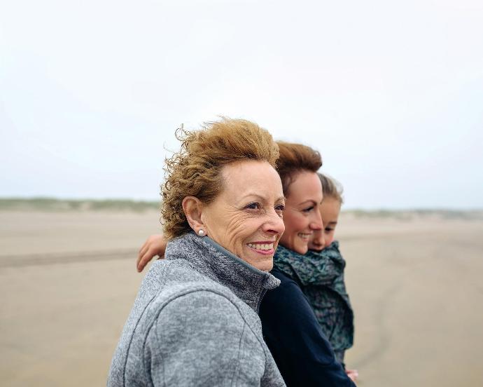 Drie lachende vrouwen op het strand